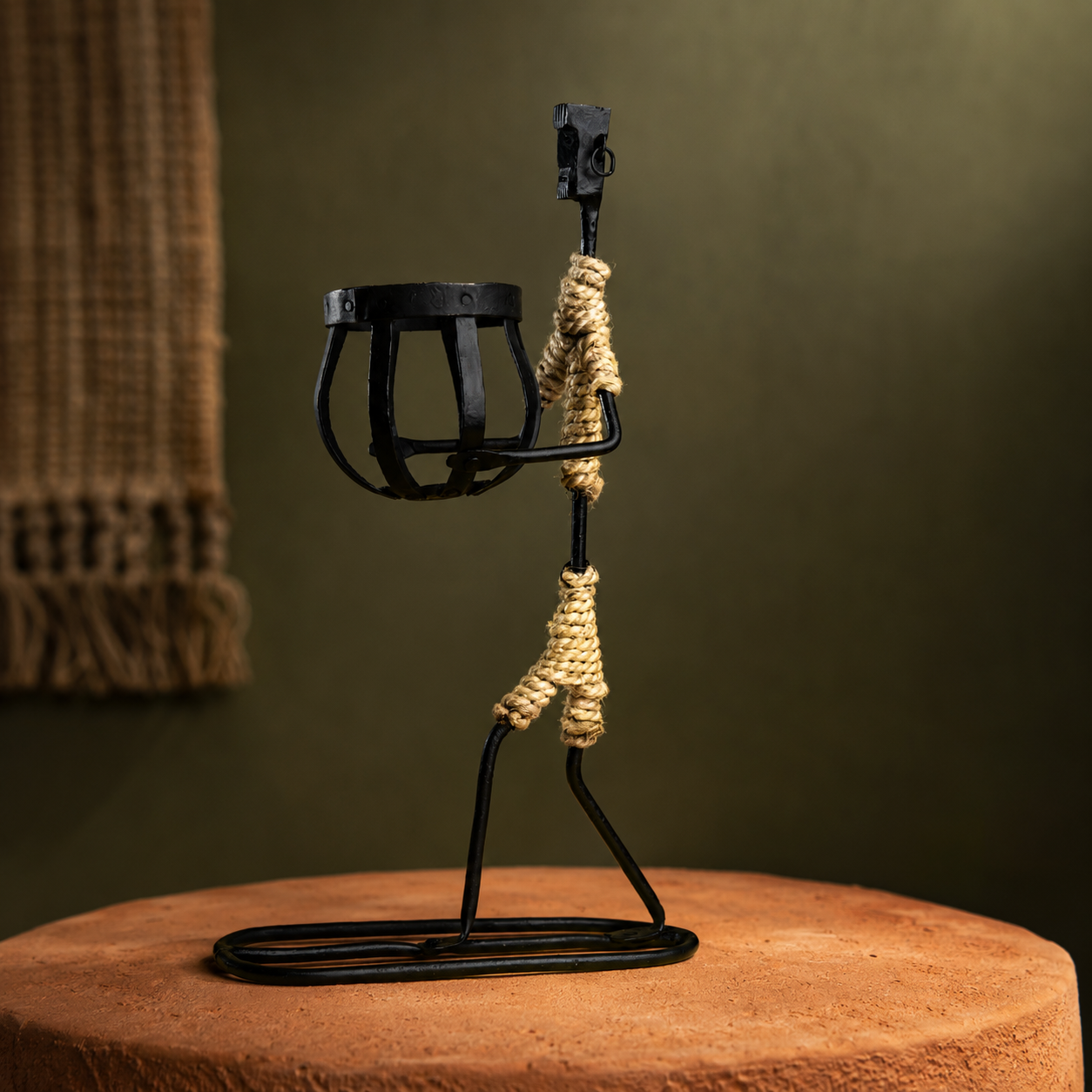 Bastar wrought iron tribal figure candle holder in an earthen craft-inspired setting