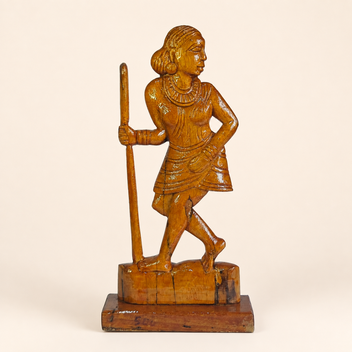 Hand-carved Bastar wooden Madin woman sculpture on a clean ivory studio background