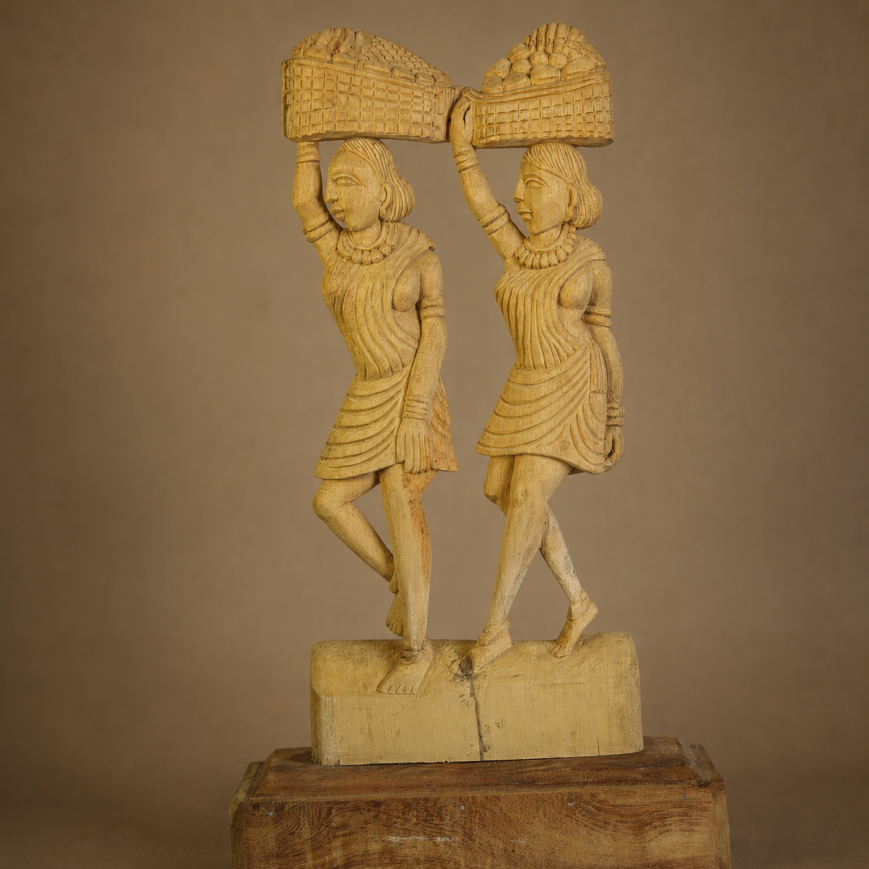 Close view of the carved faces, jewellery, garments and baskets on a Bastar wood sculpture
