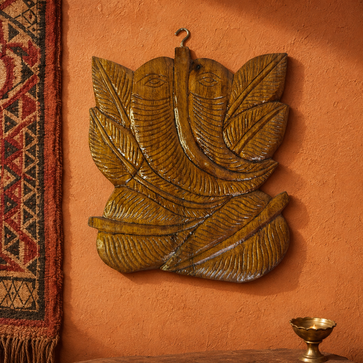 Hand-carved wooden Ganesha wall hanging in a restrained Bastar-inspired editorial setting