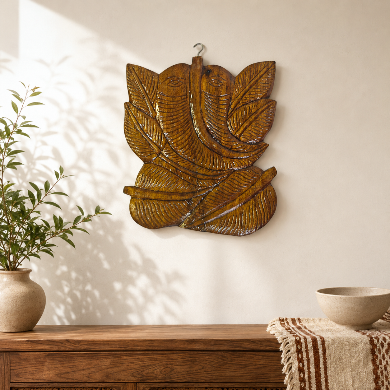 Bastar wooden Ganesha wall hanging displayed above a console in a warm entryway