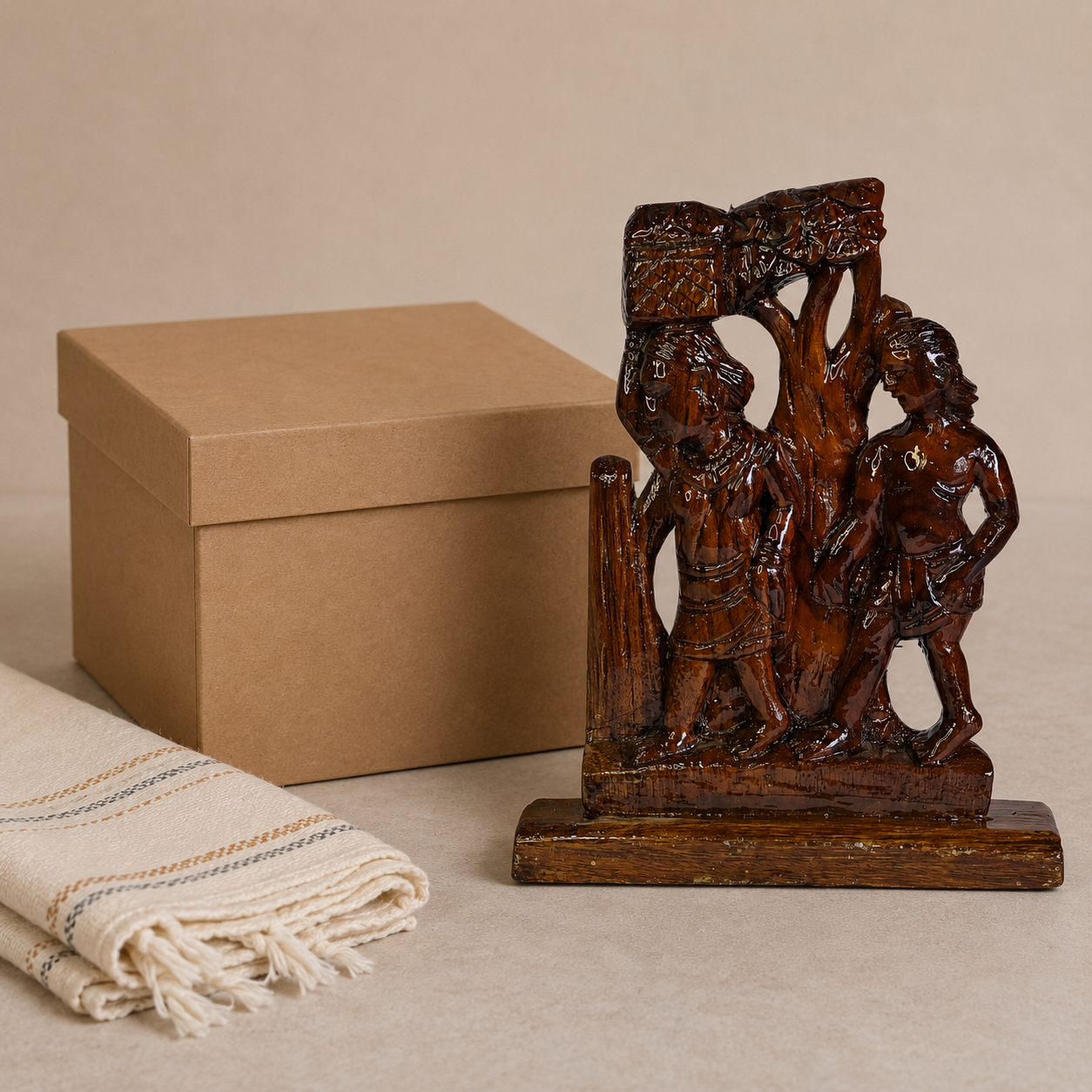 Bastar Madia-Madin wood sculpture presented beside a kraft gift box and handloom cloth