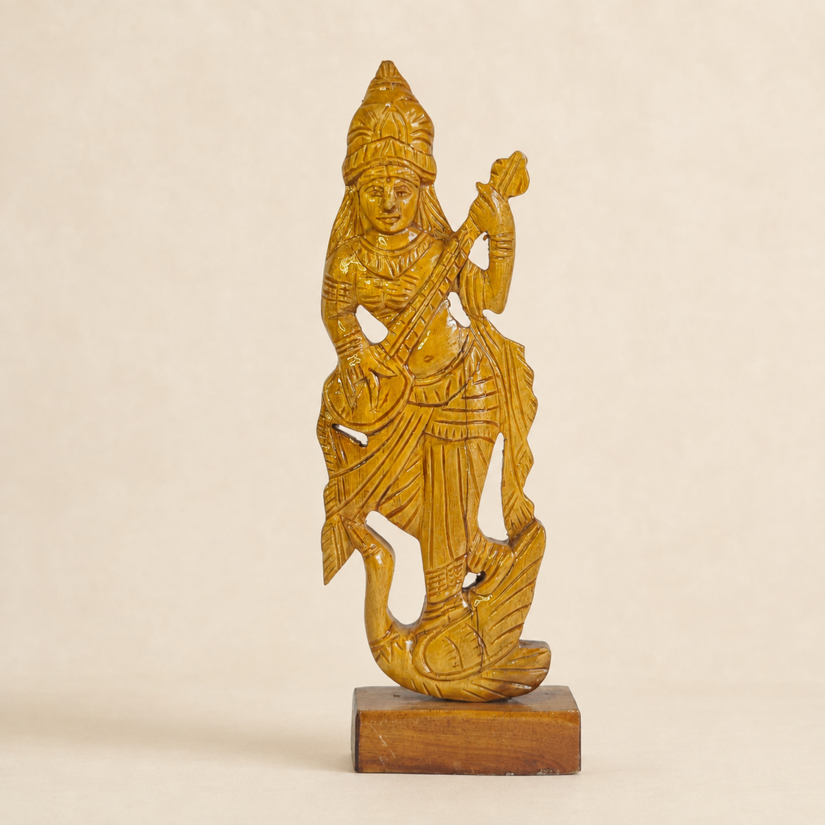 Hand-carved Bastar wooden Goddess Saraswati statue on a clean ivory studio background