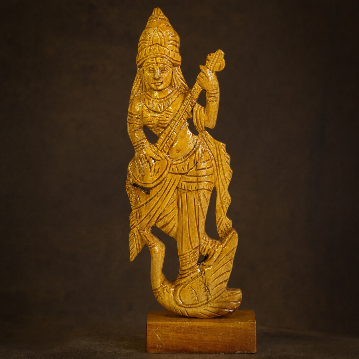 Craftsmanship view of the crown, veena, carved garments and wood grain on a Saraswati statue