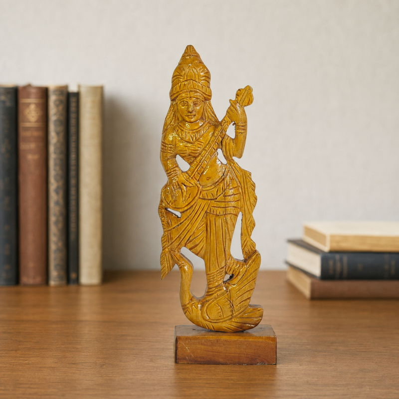 Bastar wooden Goddess Saraswati carving displayed on a study desk with books