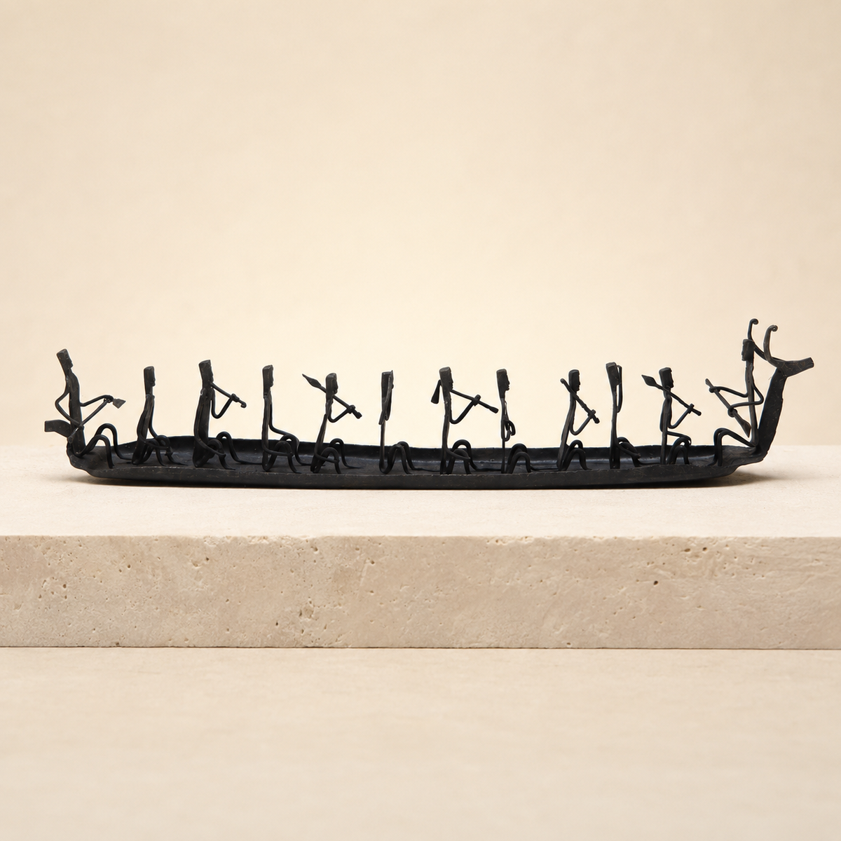 Bastar Wrought Iron Tribal Boat displayed on a warm ivory stone plinth