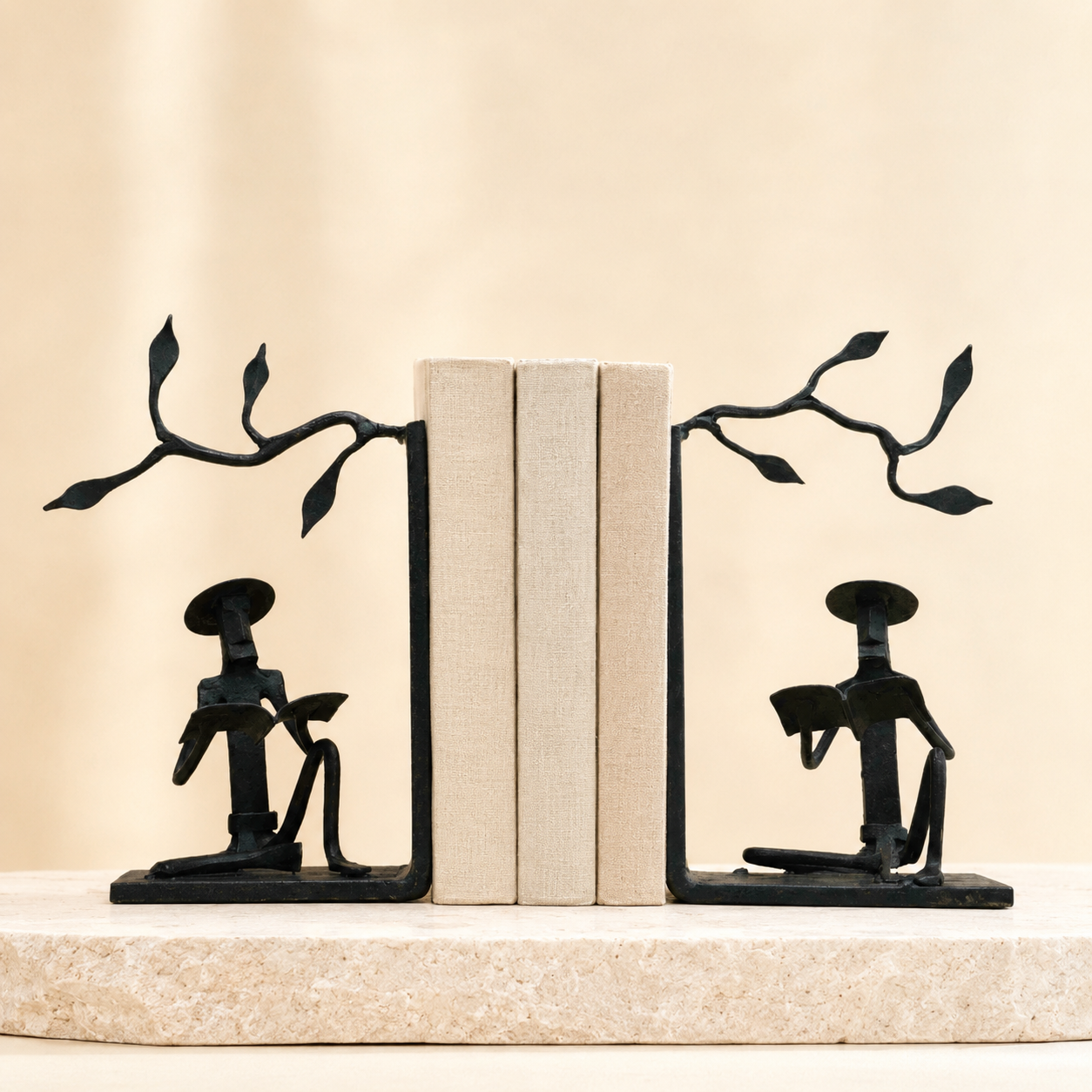 Bastar Wrought Iron Book Holder pair with neutral books on a warm stone plinth