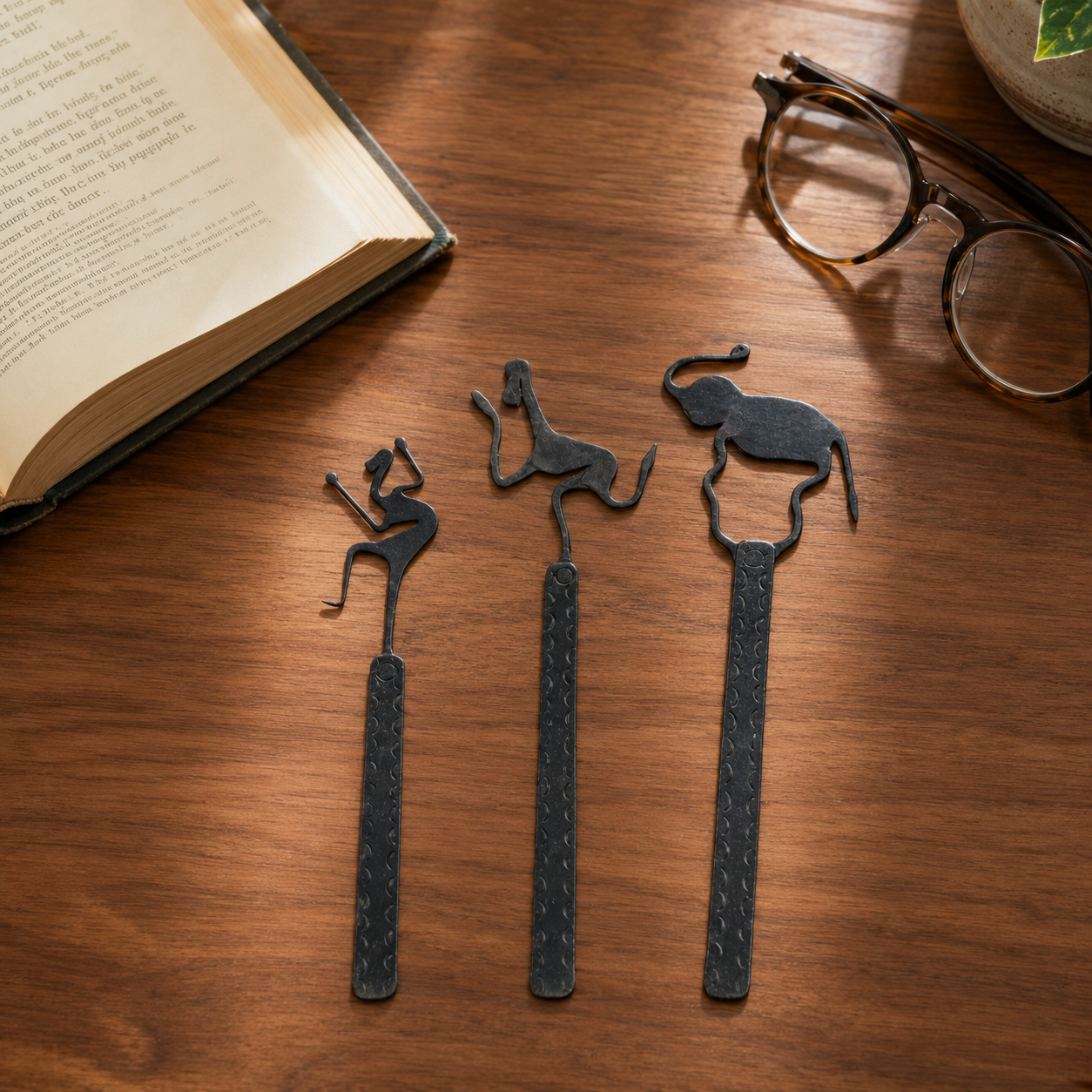 Bastar wrought iron bookmark set beside an open book and reading glasses