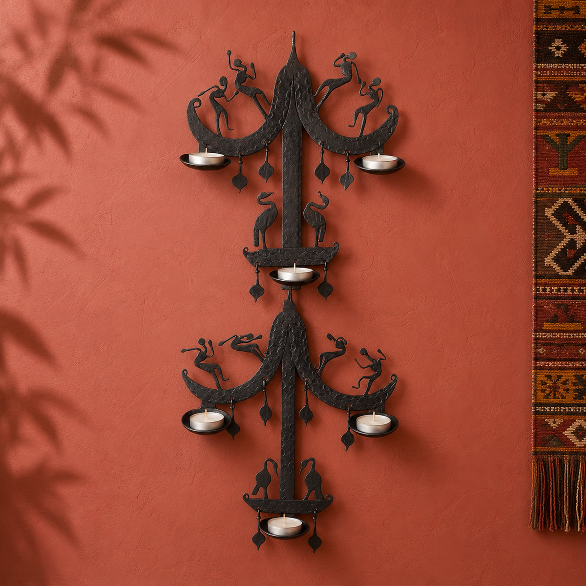 Two-tier Bastar wrought iron candle holder displayed on an ochre gallery wall