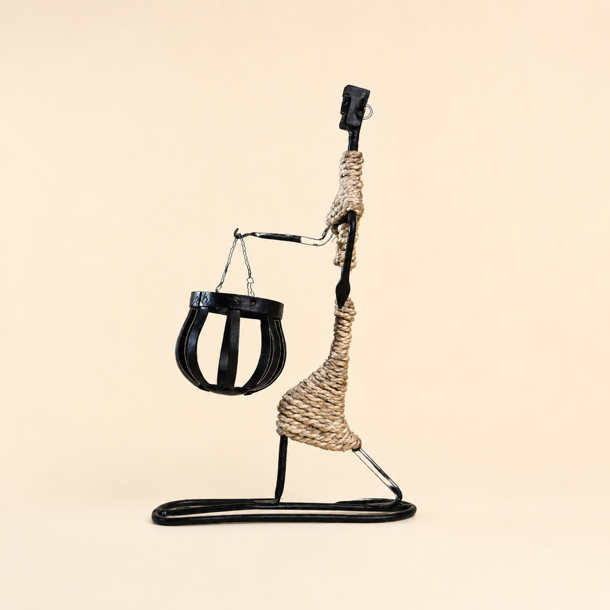 Bastar wrought iron profile figure candle holder with a chain-suspended basket on an ivory background