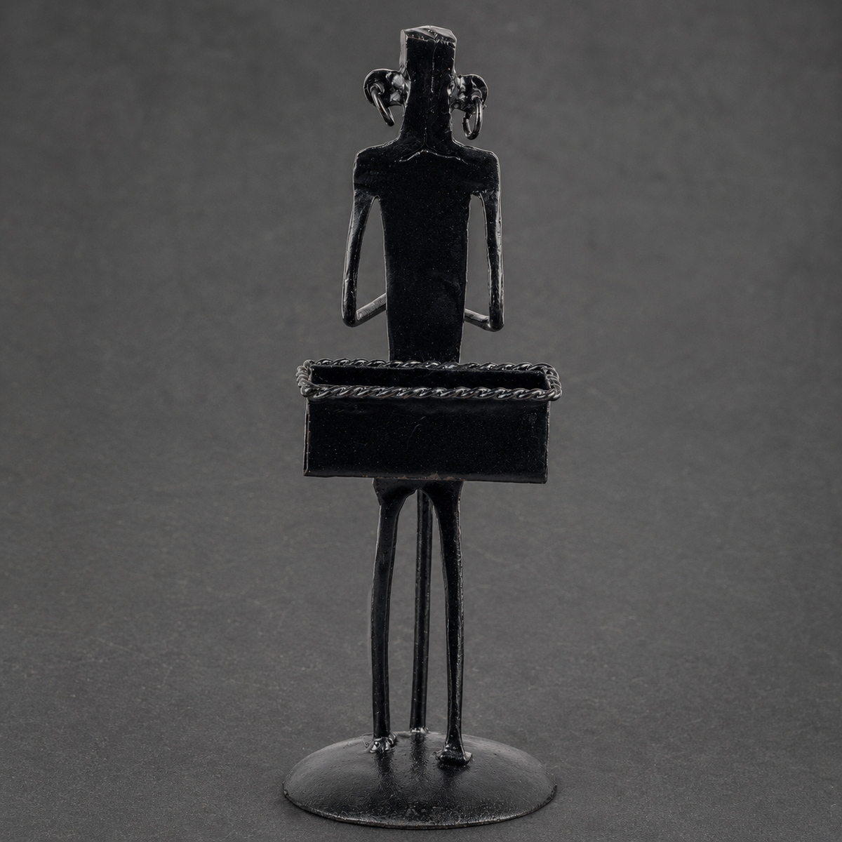 Craft detail of the rope-edged trough and forged figure on a Bastar iron card holder