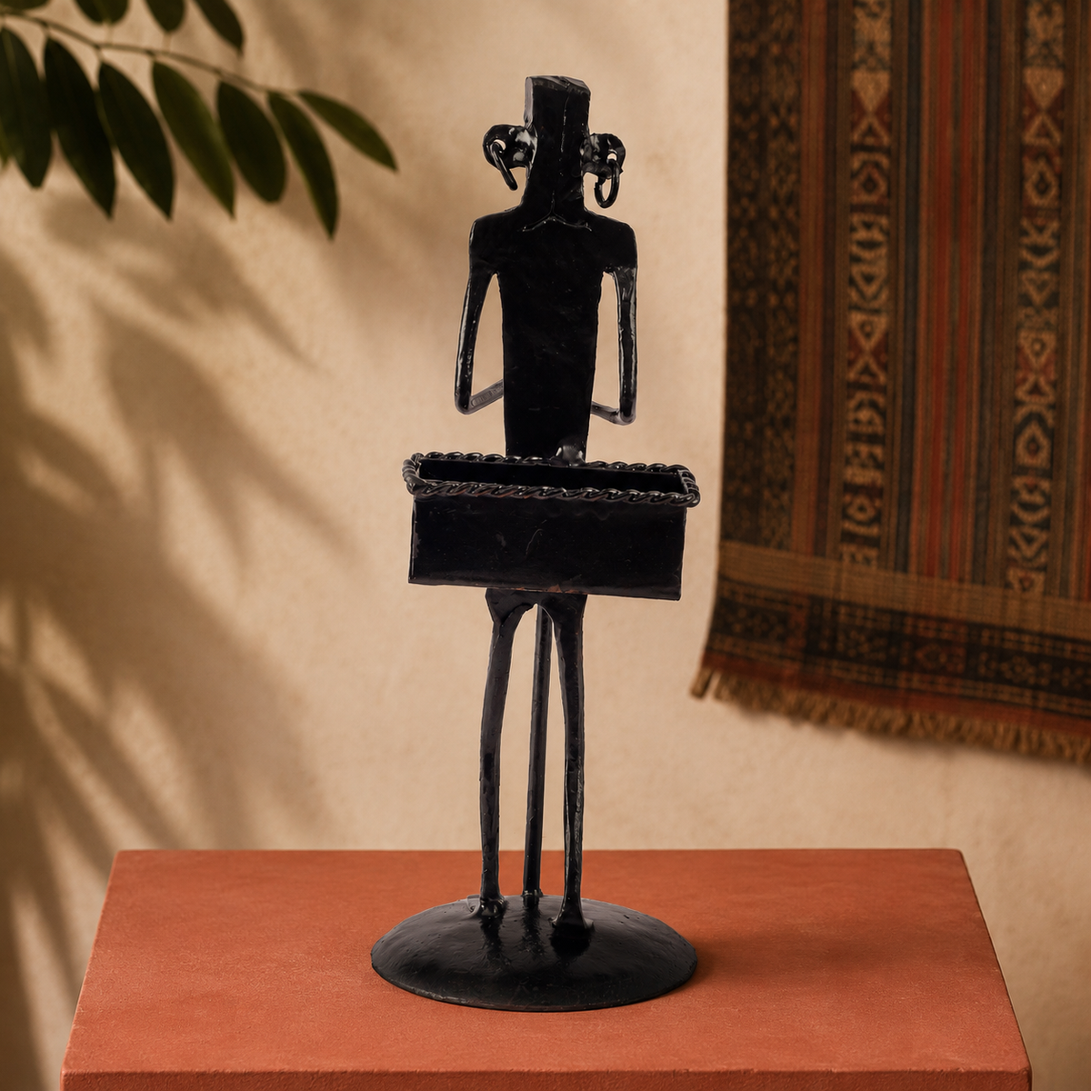 Hand-forged Bastar iron card holder displayed on an ochre gallery plinth