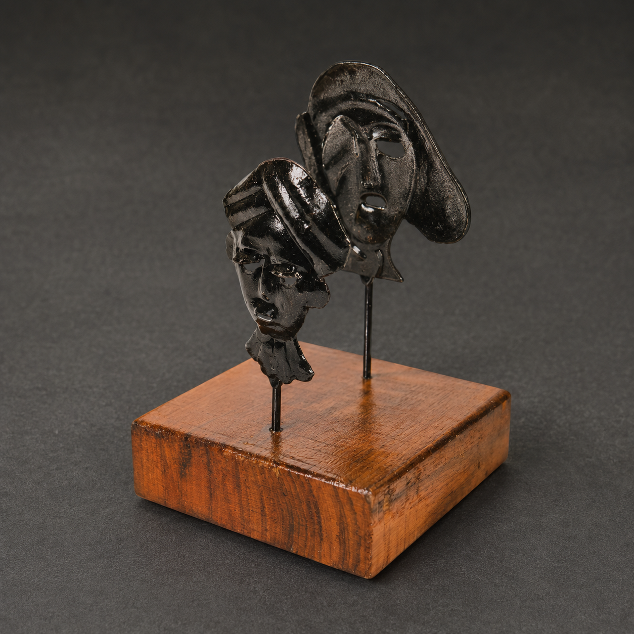 Close view of the forged tribal masks and wooden base of a Bastar card holder