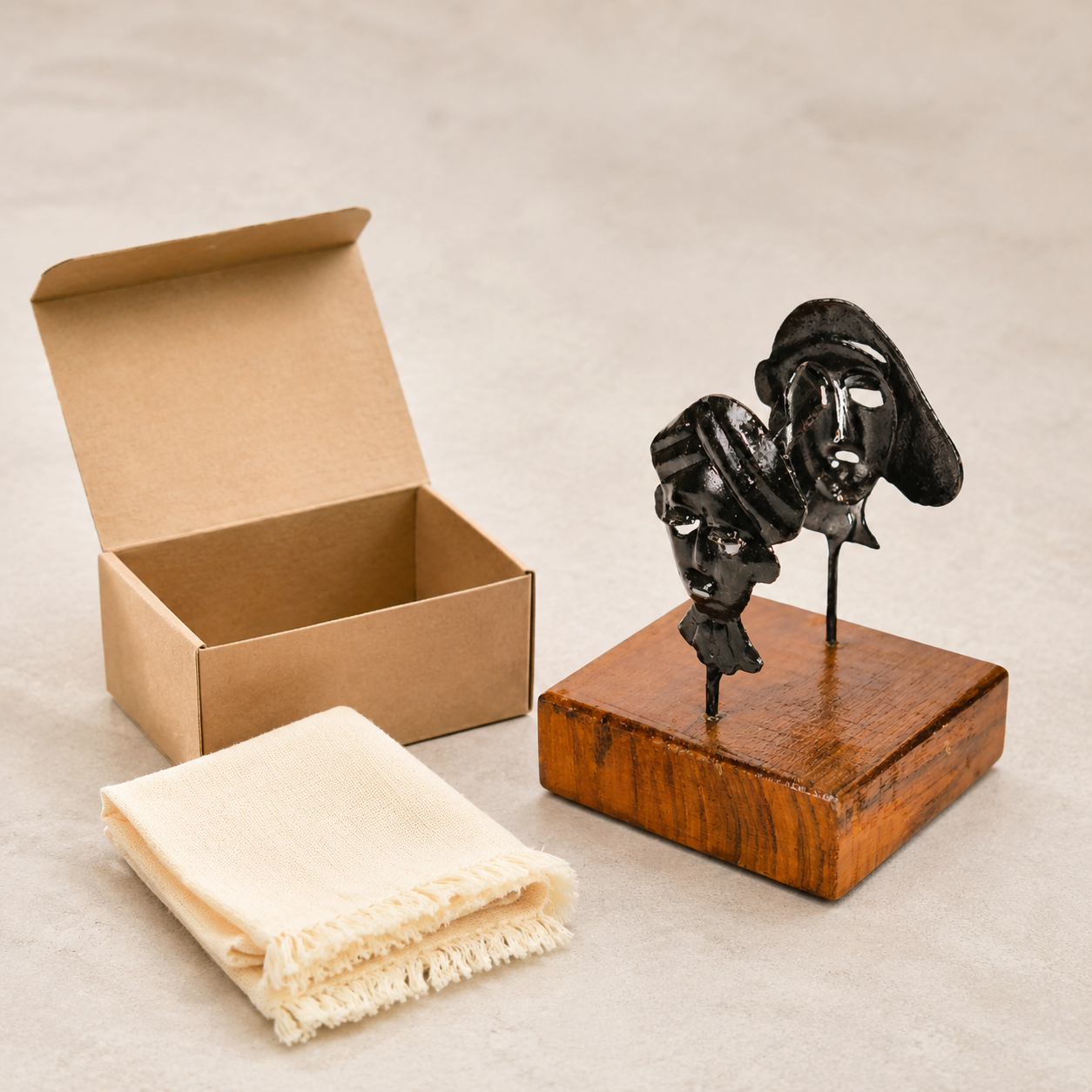 Bastar wrought iron two-mask card holder displayed beside a kraft gift box