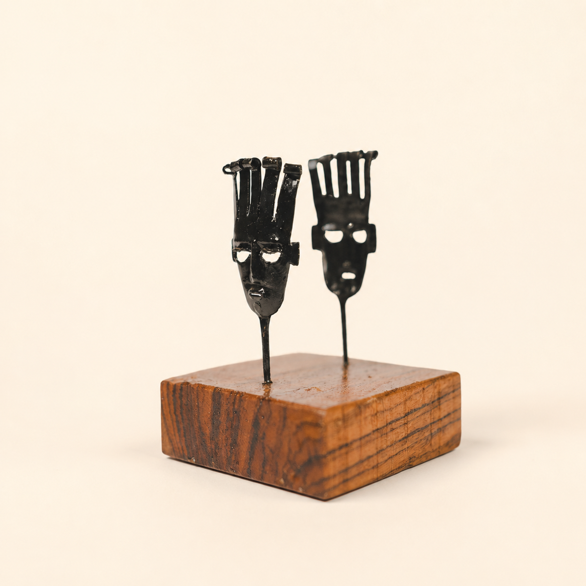 Bastar wrought iron two-mask card holder on a warm ivory studio background