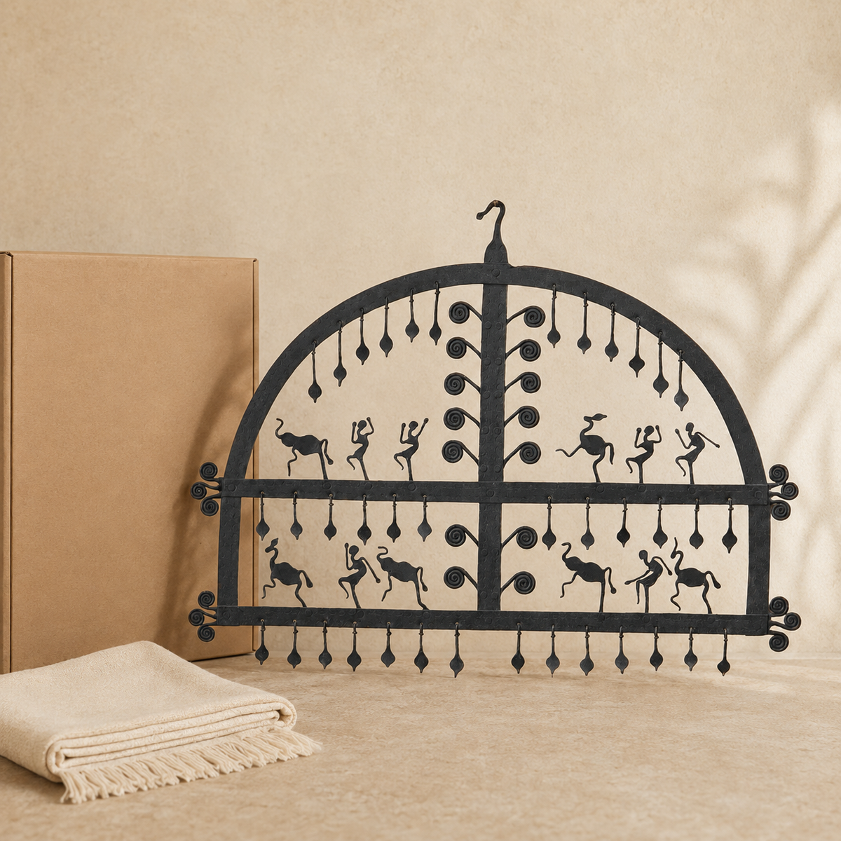 Hand-forged Bastar wrought iron decorative frame with tribal dancers and animals presented beside a gift box