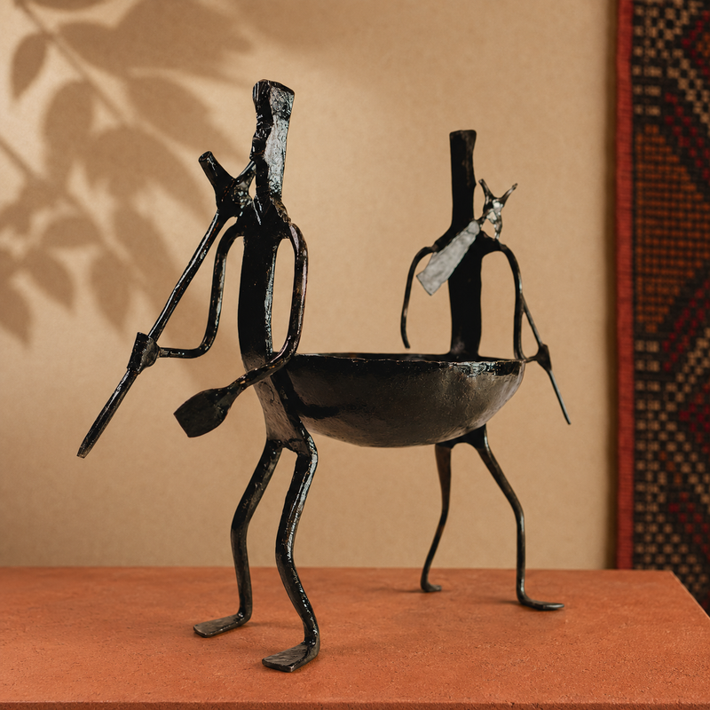 Hand-forged Bastar dry fruit holder displayed on an ochre artisan gallery plinth