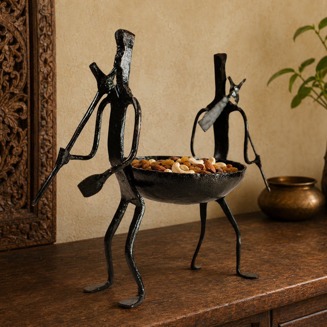 Tribal wrought iron dry fruit holder filled with almonds, cashews and raisins on a console