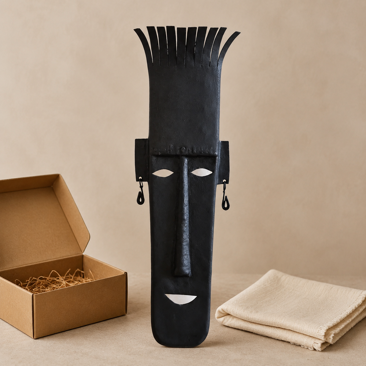 Bastar wrought iron tall-crown face mask displayed beside an open gift box