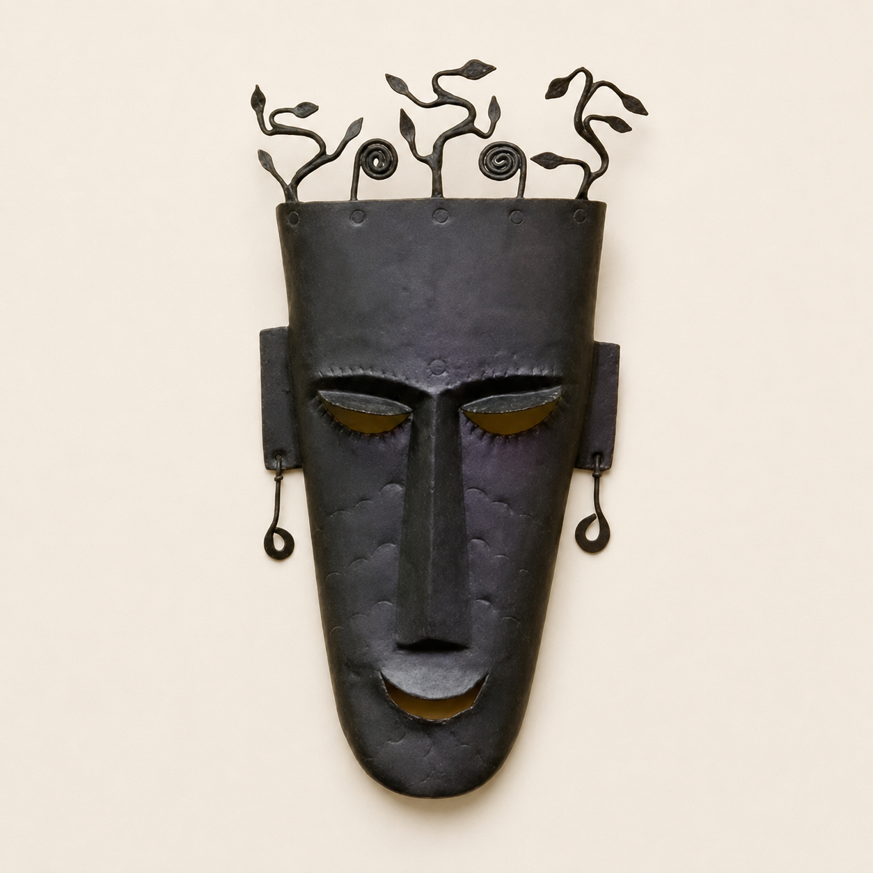 Bastar wrought iron face mask with leafy crown and ochre accents on an ivory background