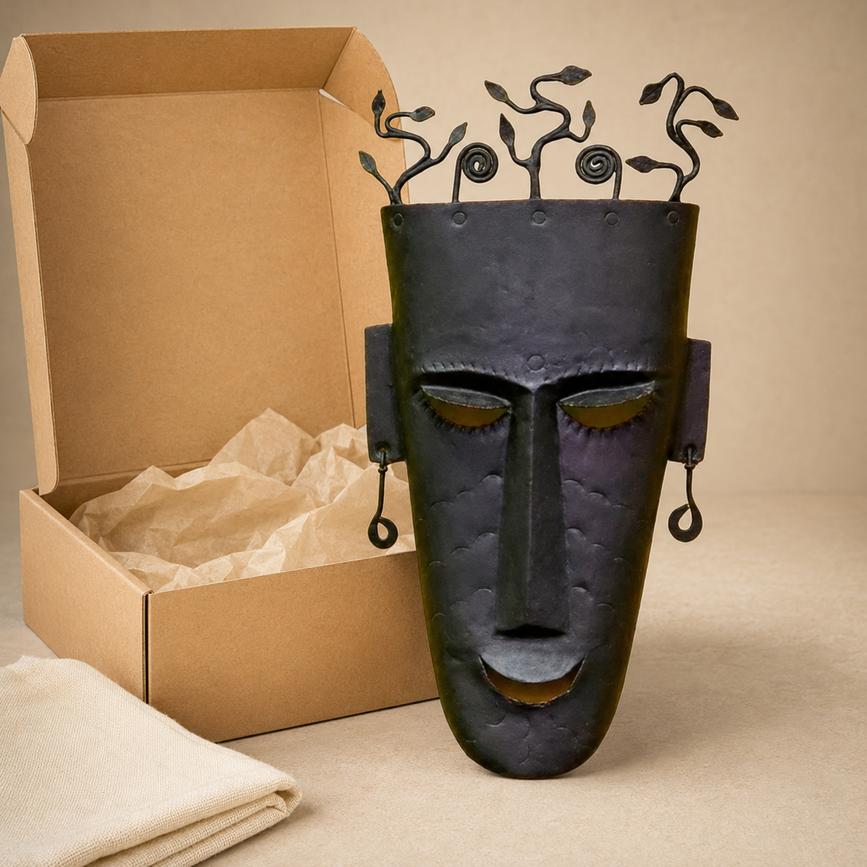 Bastar wrought iron face mask presented beside a kraft gift box
