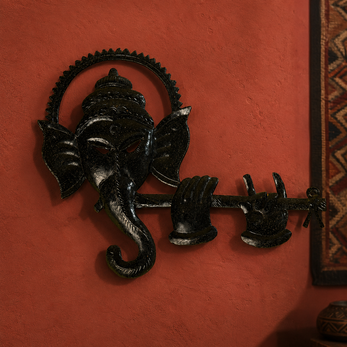 Bastar iron Ganesh wall panel displayed on an ochre artisan gallery wall