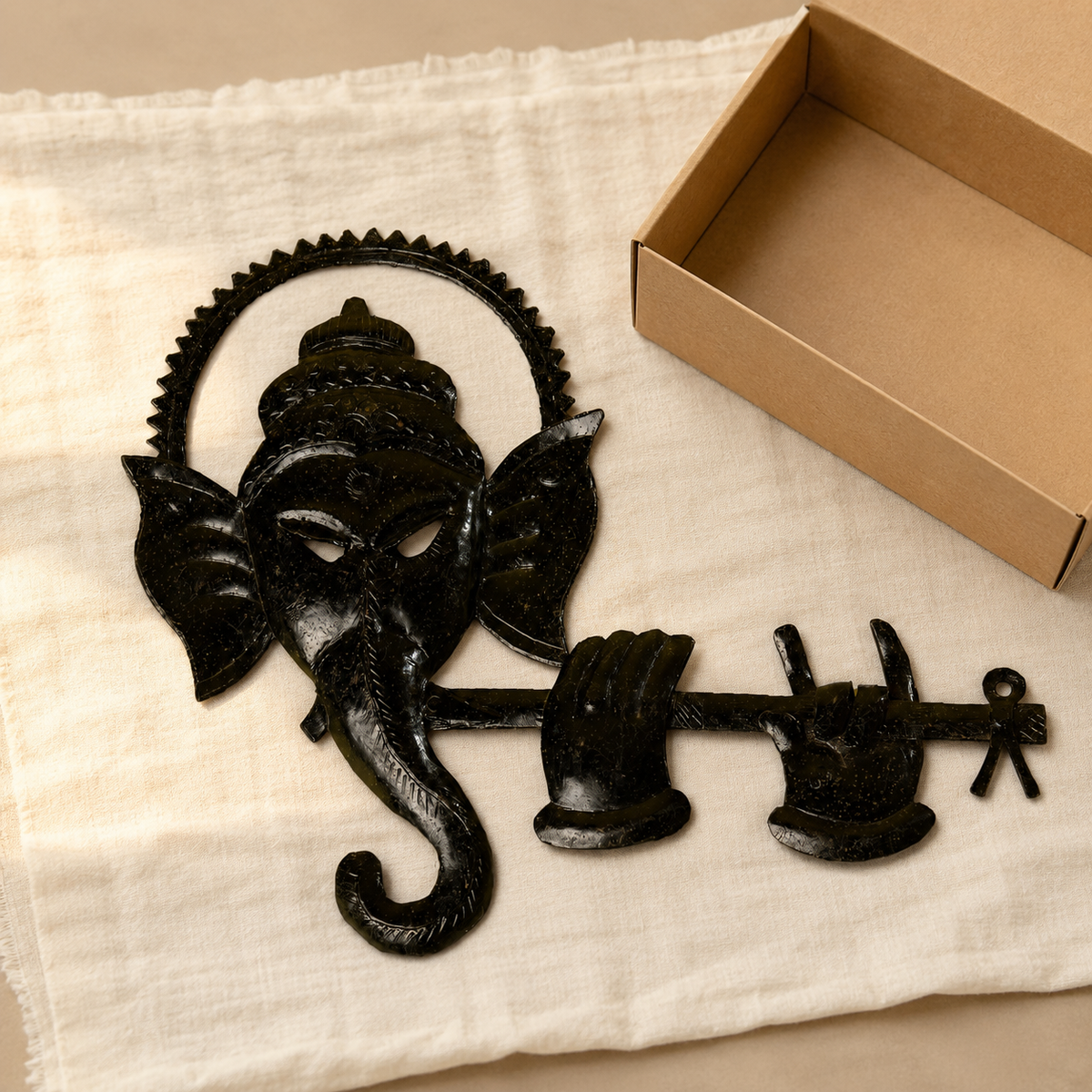 Bastar wrought iron Ganesh flute wall décor arranged beside an open gift box