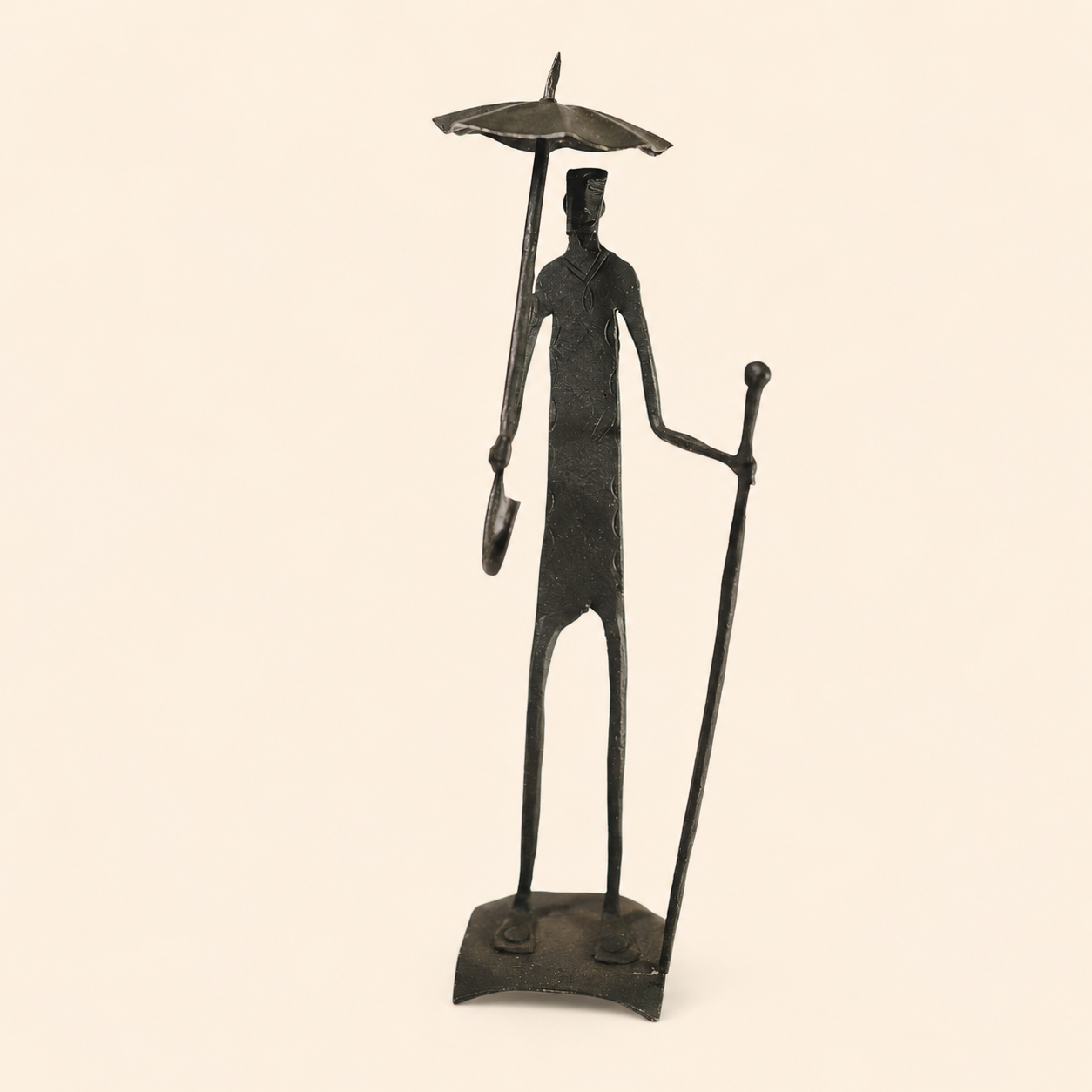 Bastar wrought iron human figure with umbrella and staff on an ivory catalogue background