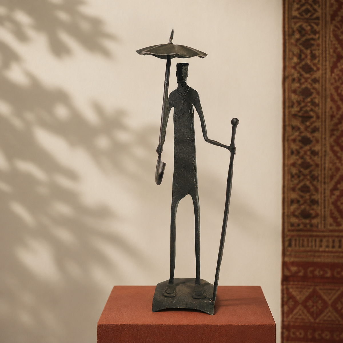Hand-forged Bastar human figure sculpture displayed on an ochre gallery plinth