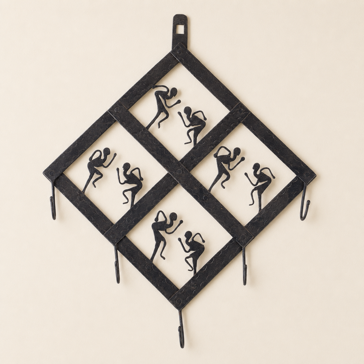 Bastar wrought iron diamond key hanger with eight dancers and five hooks on an ivory wall