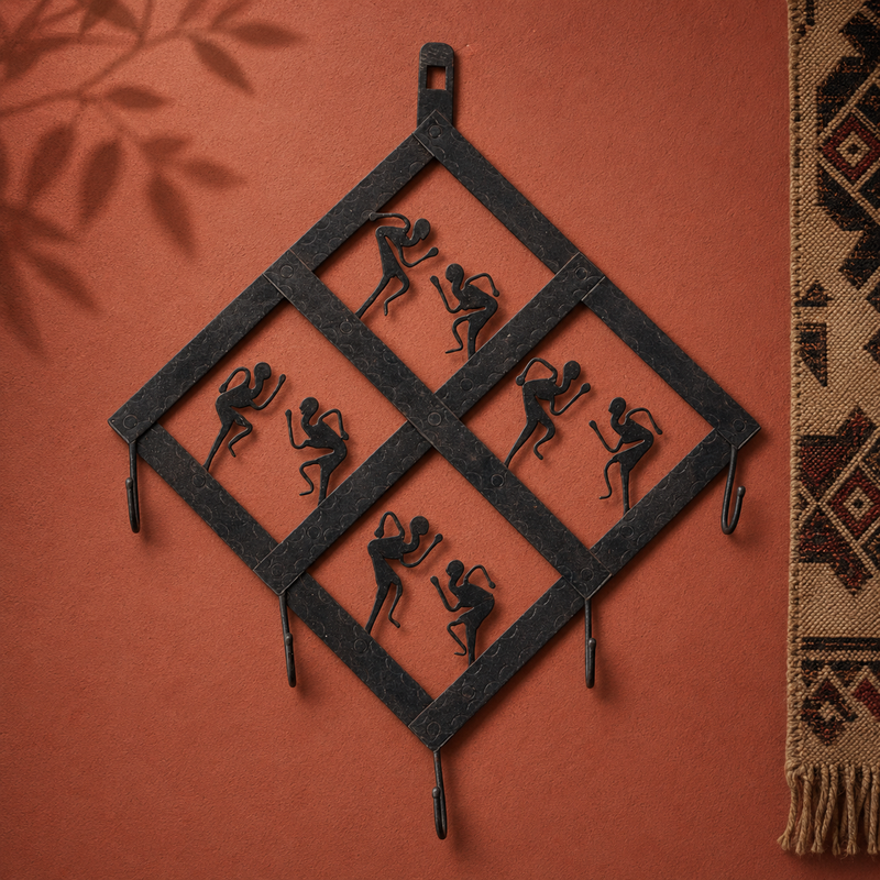 Hand-forged Bastar dancer key hanger displayed on an ochre gallery wall