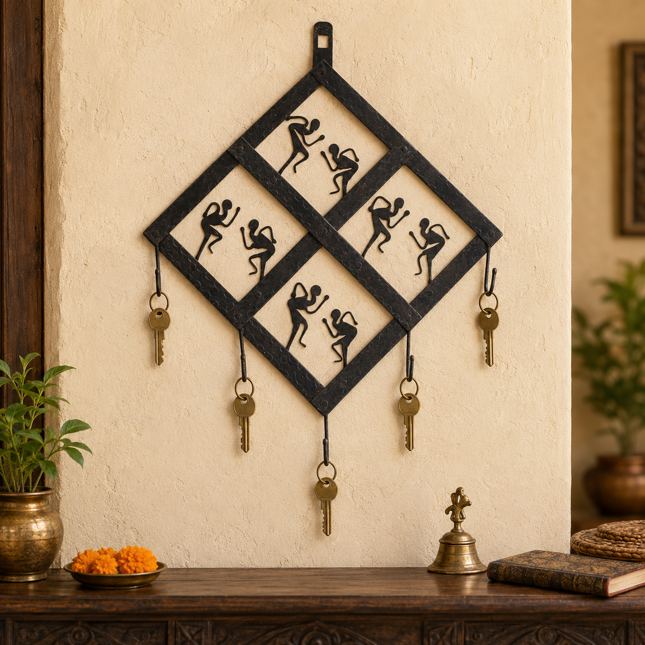 Wrought iron dancer key hanger holding five brass keys in a warm entryway