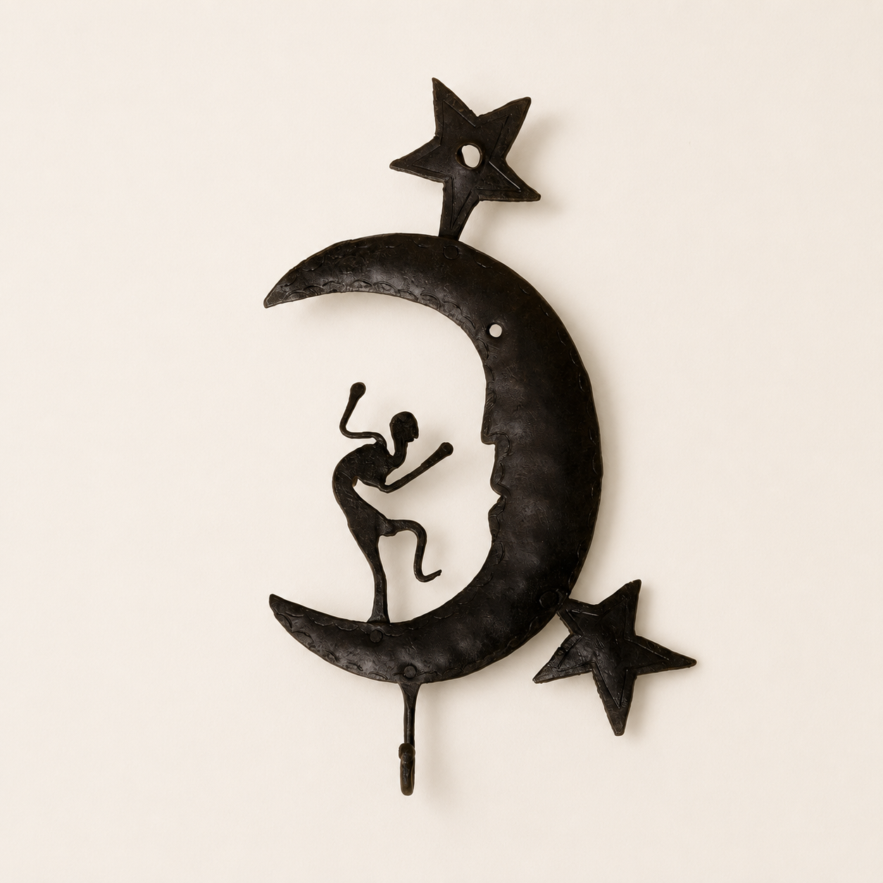 Bastar wrought iron crescent key hanger with dancer and two stars on an ivory wall