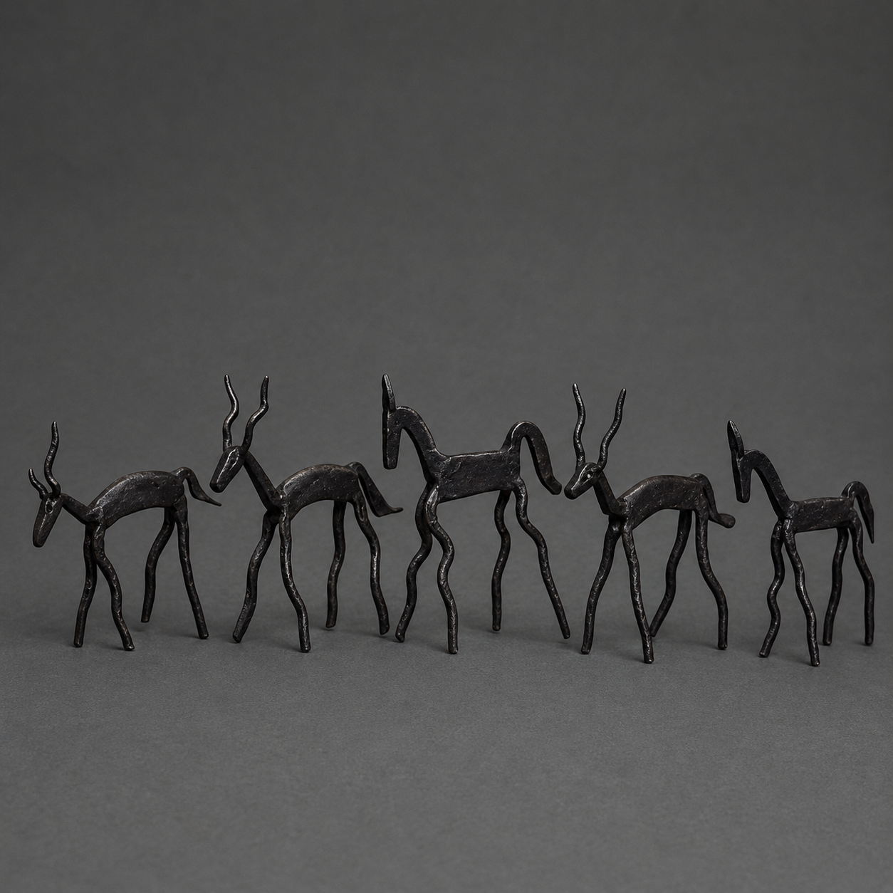 Detailed view of the forged horns, legs and black patina of a five-animal iron miniature