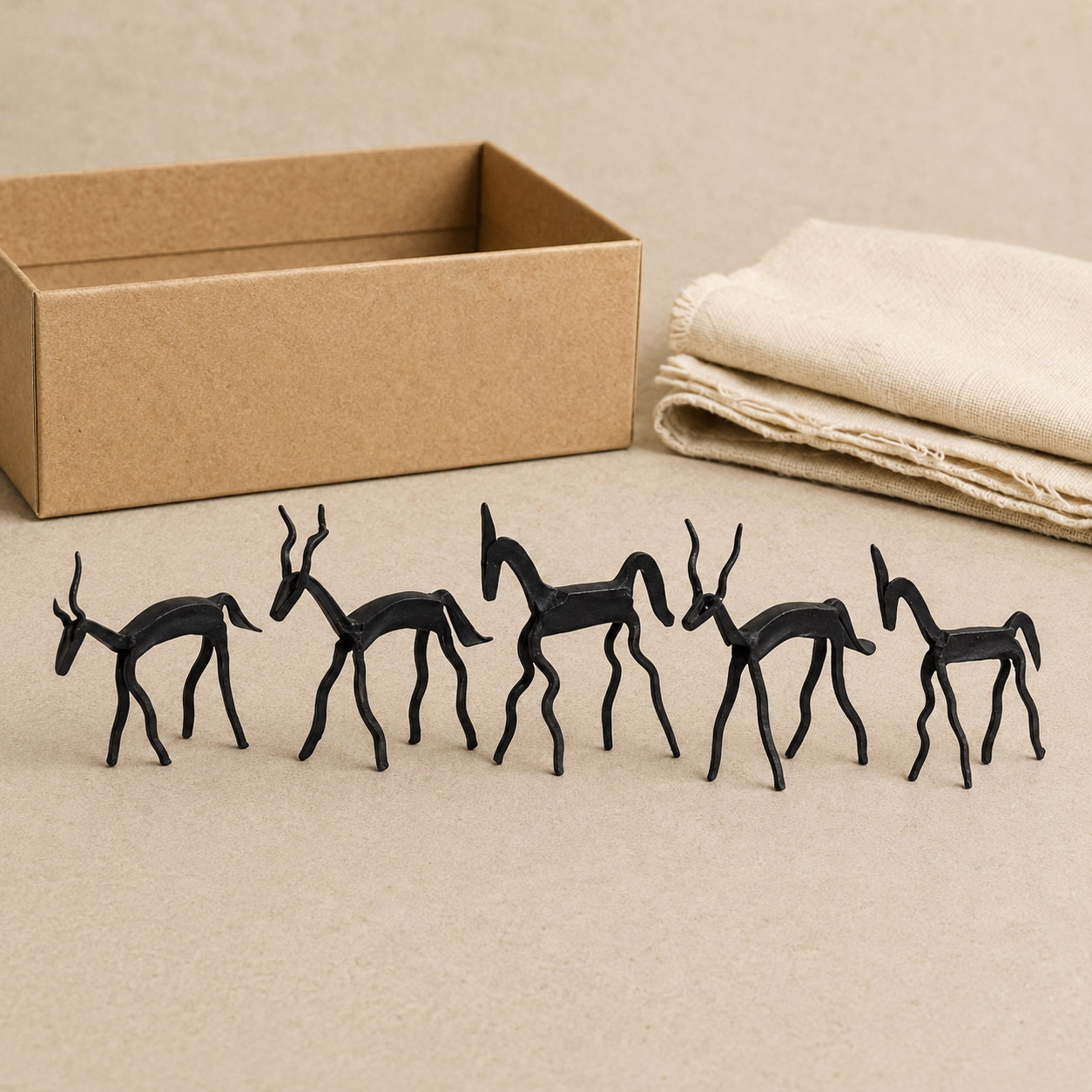 Five-animal Bastar wrought iron miniature presented beside a kraft gift box