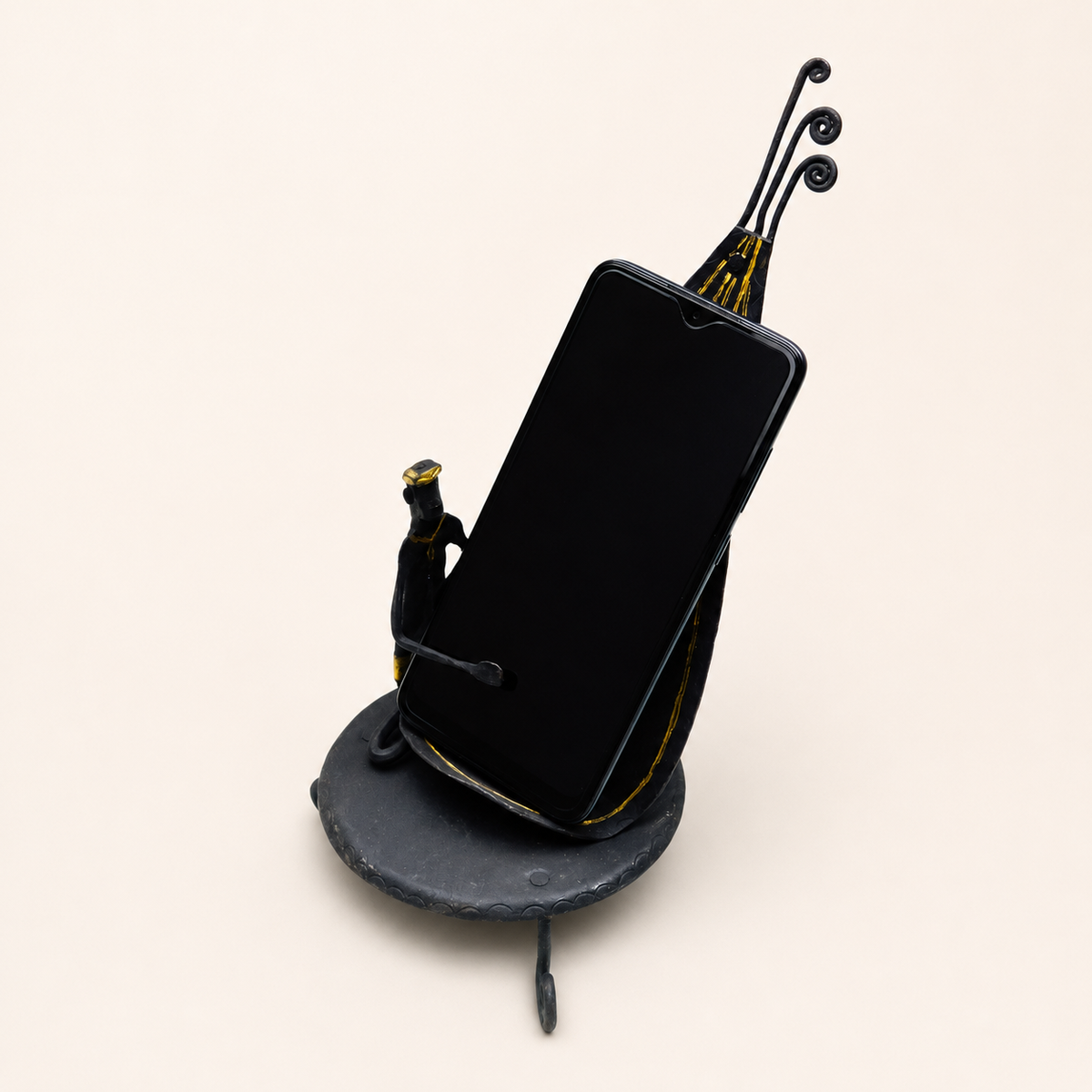 Bastar wrought iron mobile holder with a black phone on a clean studio backdrop