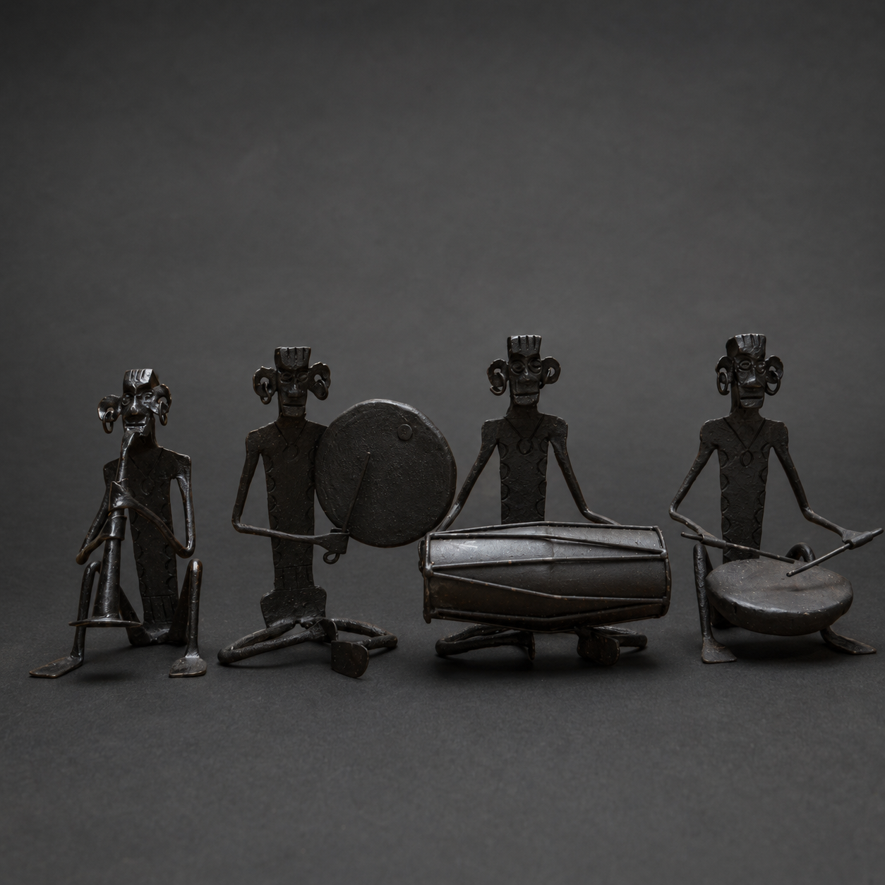 Craft detail of four forged iron musician figures with traditional instruments