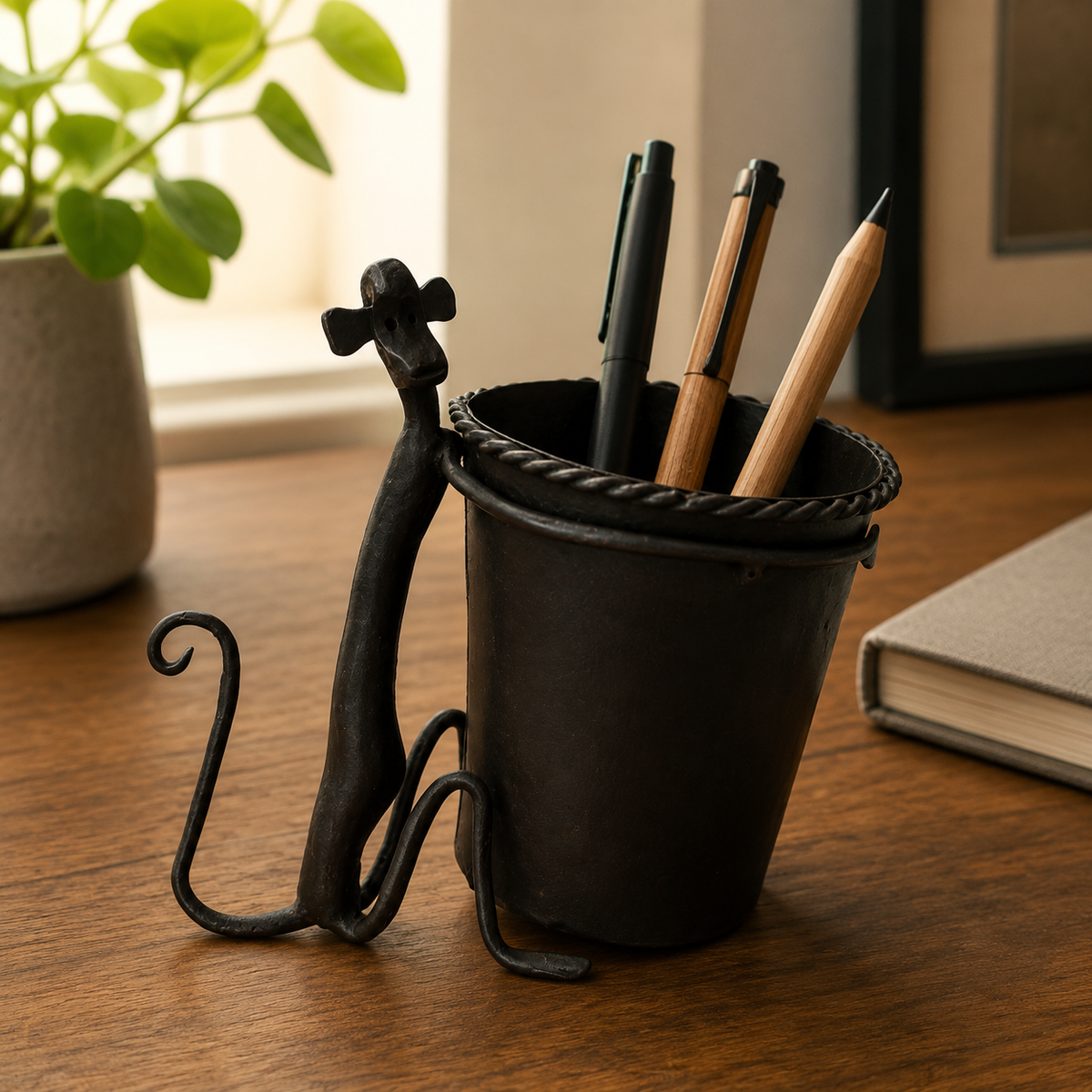 Bastar wrought iron pen stand with writing instruments on a warm wooden desk