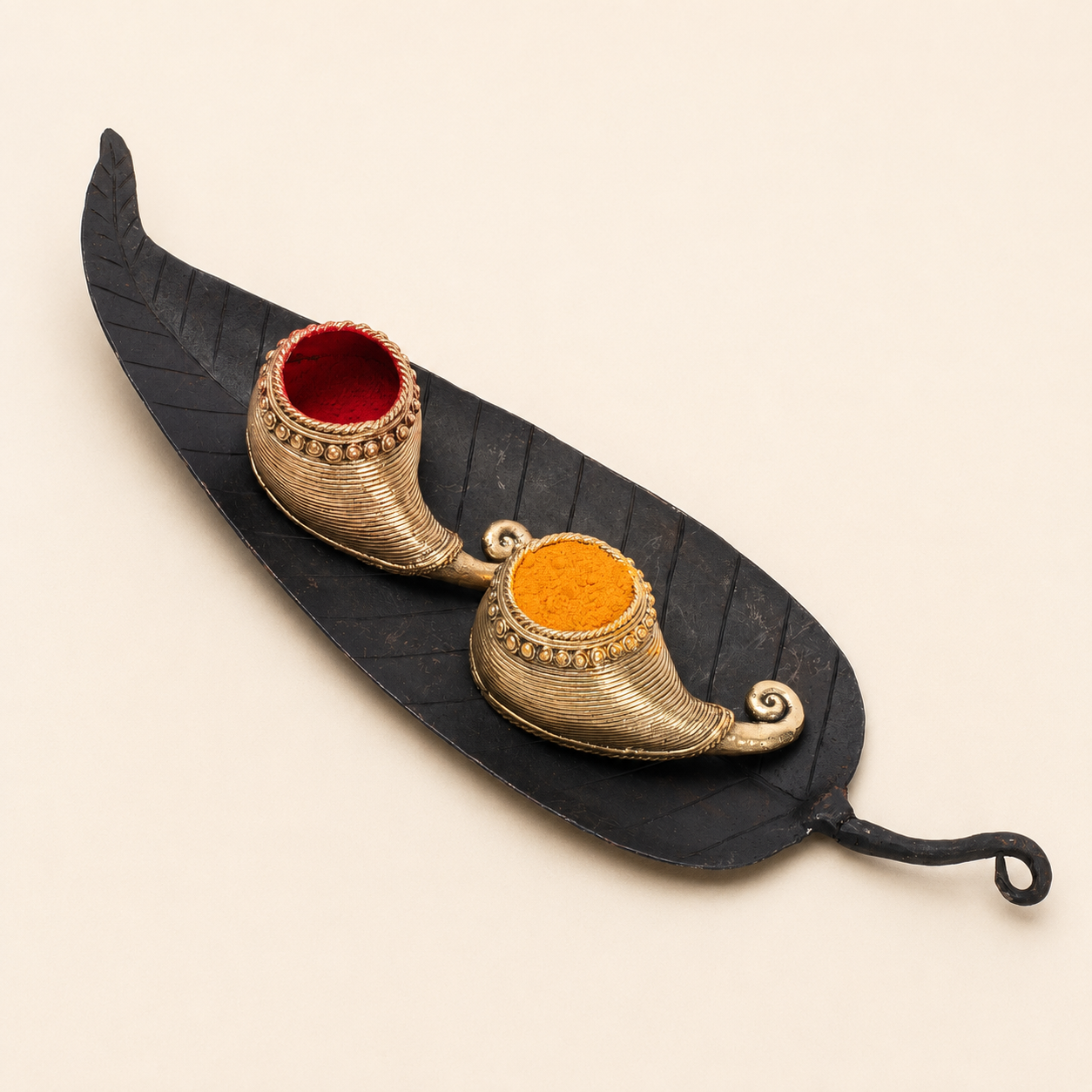 Bastar wrought iron sindoor holder with two gold-toned vessels on a leaf tray, catalogue view