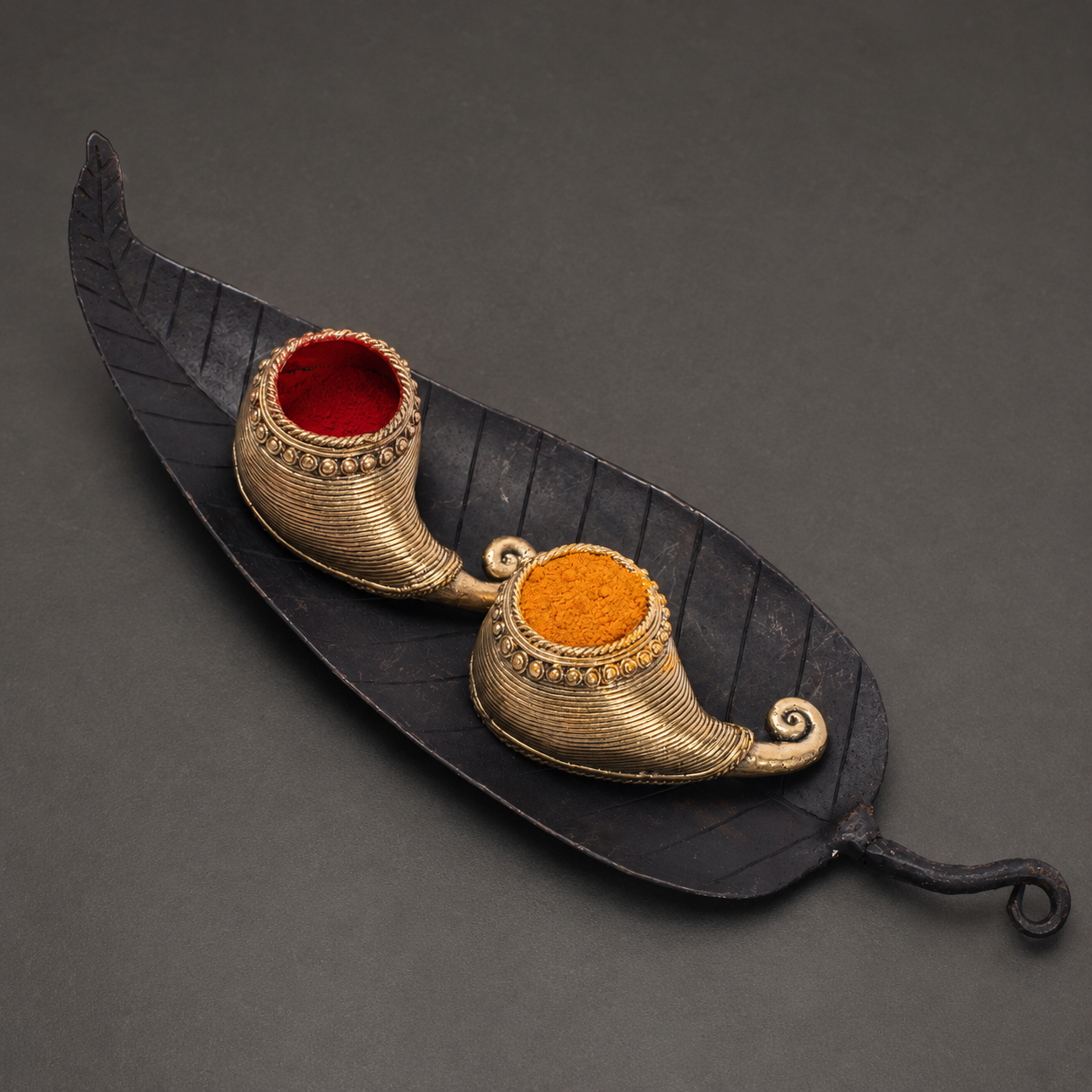 Close view of the forged leaf tray and detailed gold-toned sindoor vessels