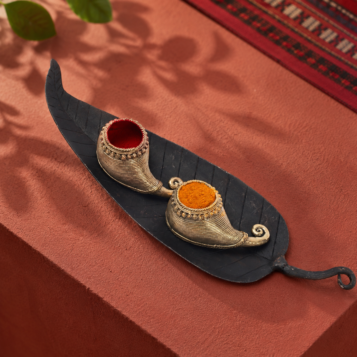 Bastar wrought iron sindoor holder in a warm terracotta editorial setting