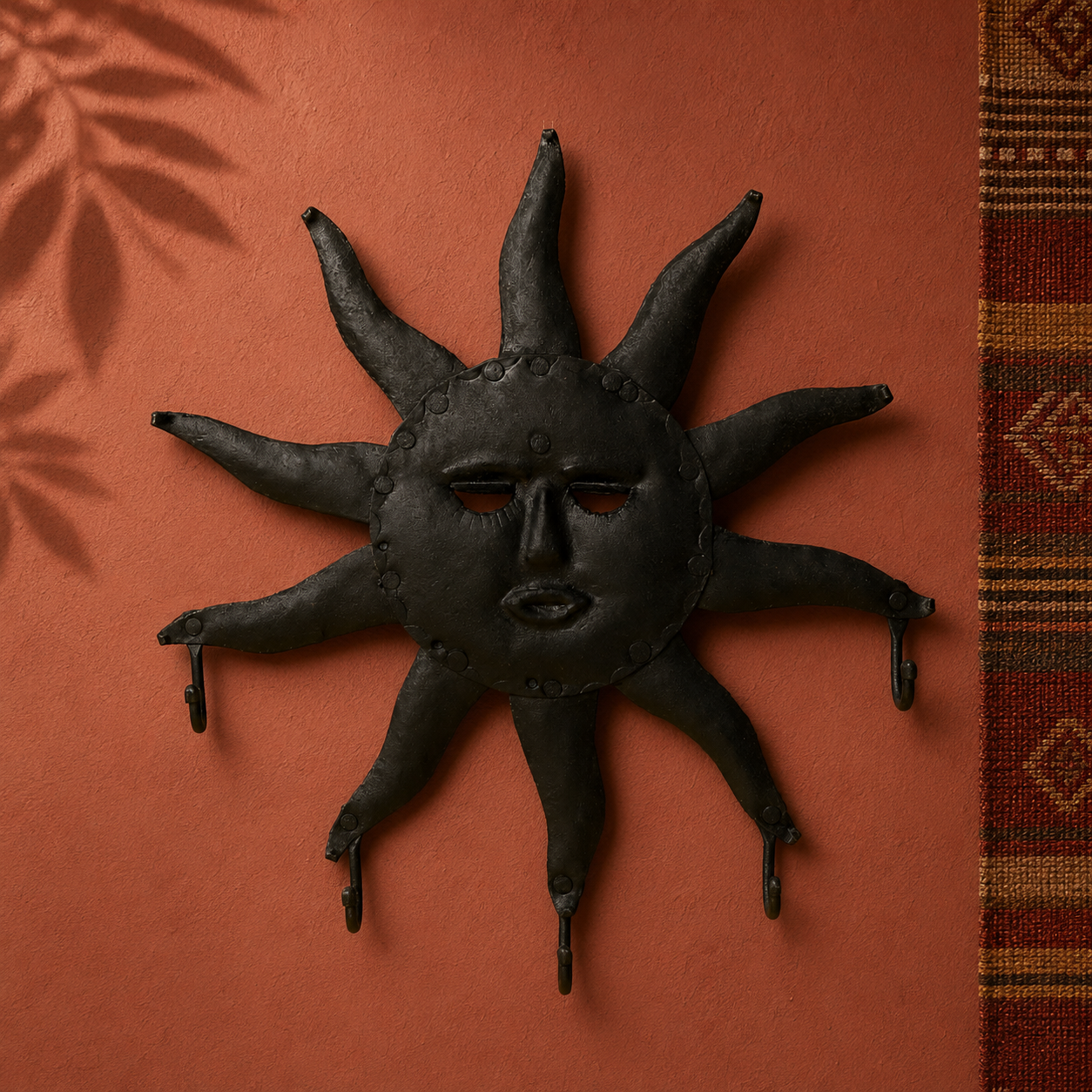 Hand-forged Bastar sun key hanger displayed on an ochre gallery wall