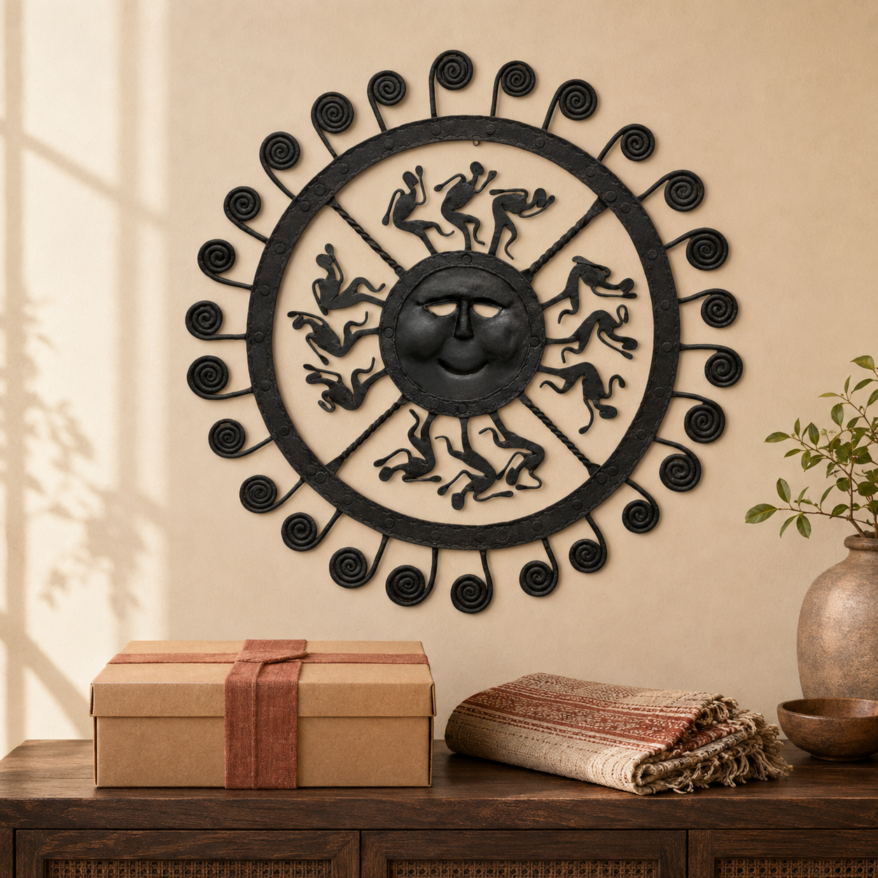 Bastar wrought iron sun wall decor styled above a kraft gift box and folded handloom cloth