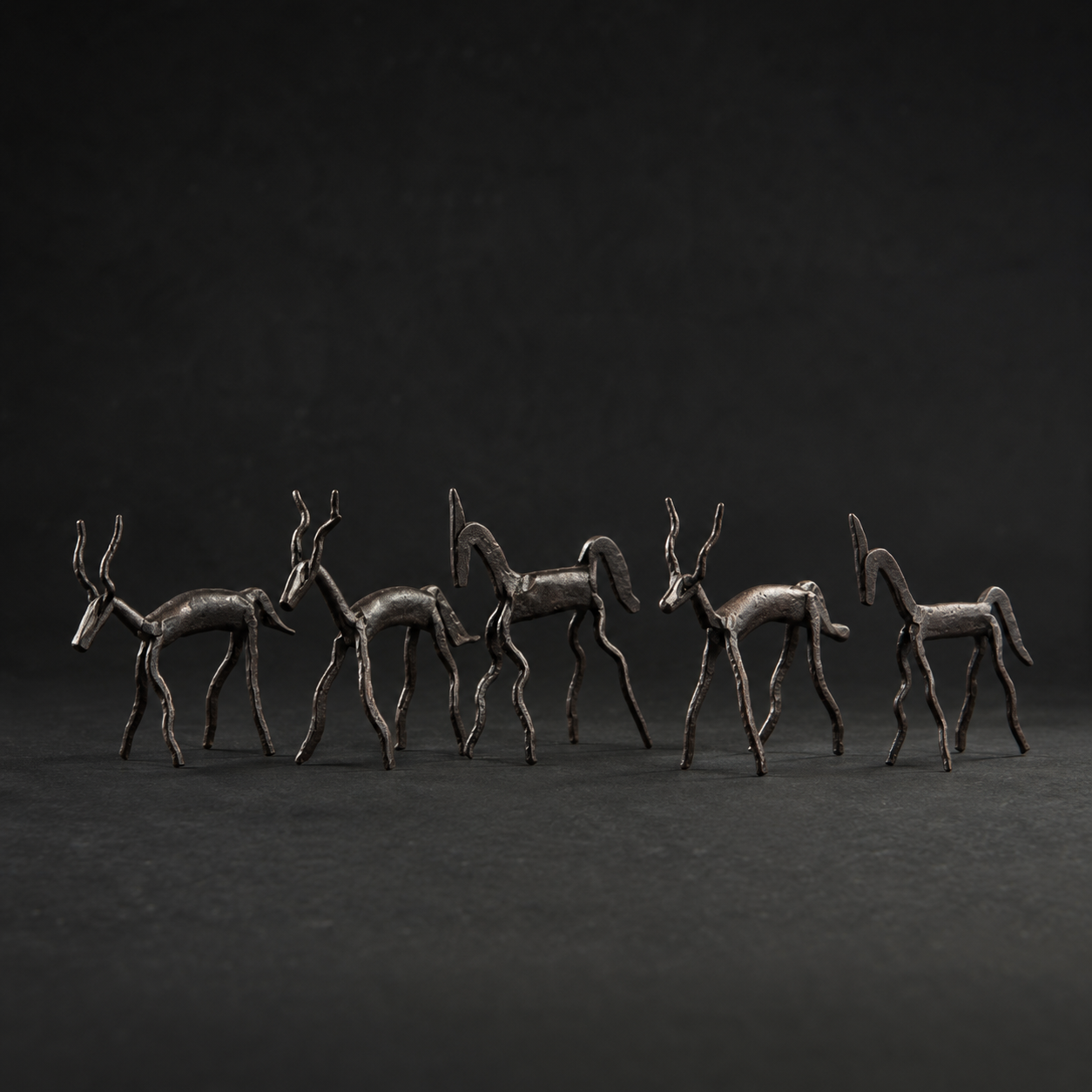 Detailed view of the hand-forged deer and horse figures in the tribal animal set