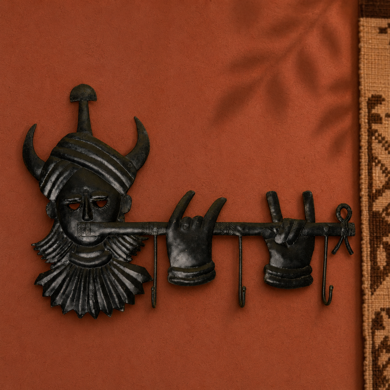 Hand-forged Bastar tribal key hanger displayed on an ochre gallery wall