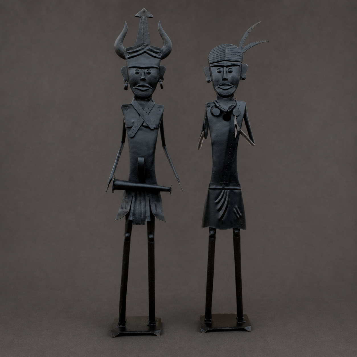 Detailed view of the headdresses, ornaments and blackened finish of two Bastar iron figures