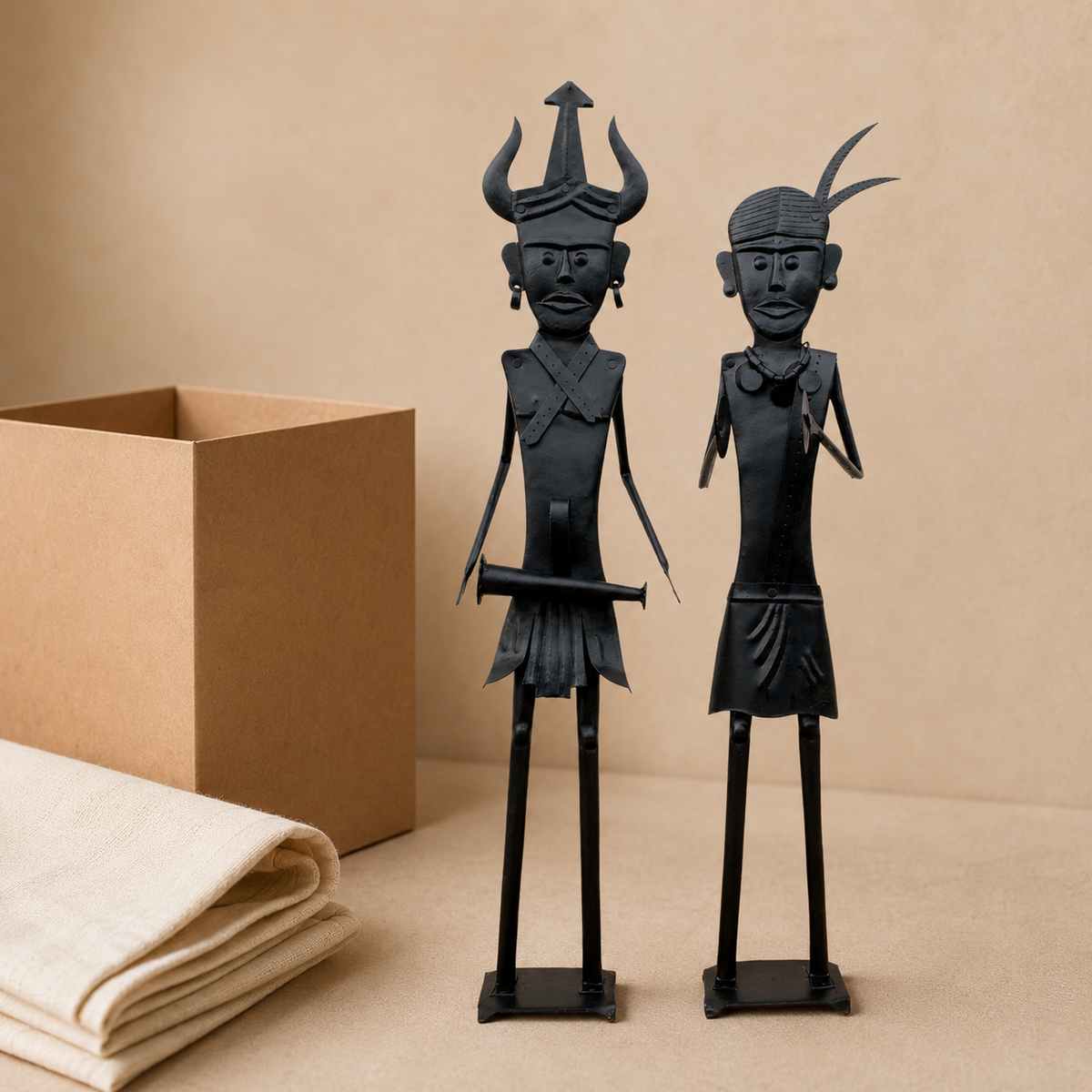 Two-piece Bastar wrought iron tribal figurine set presented beside a kraft gift box