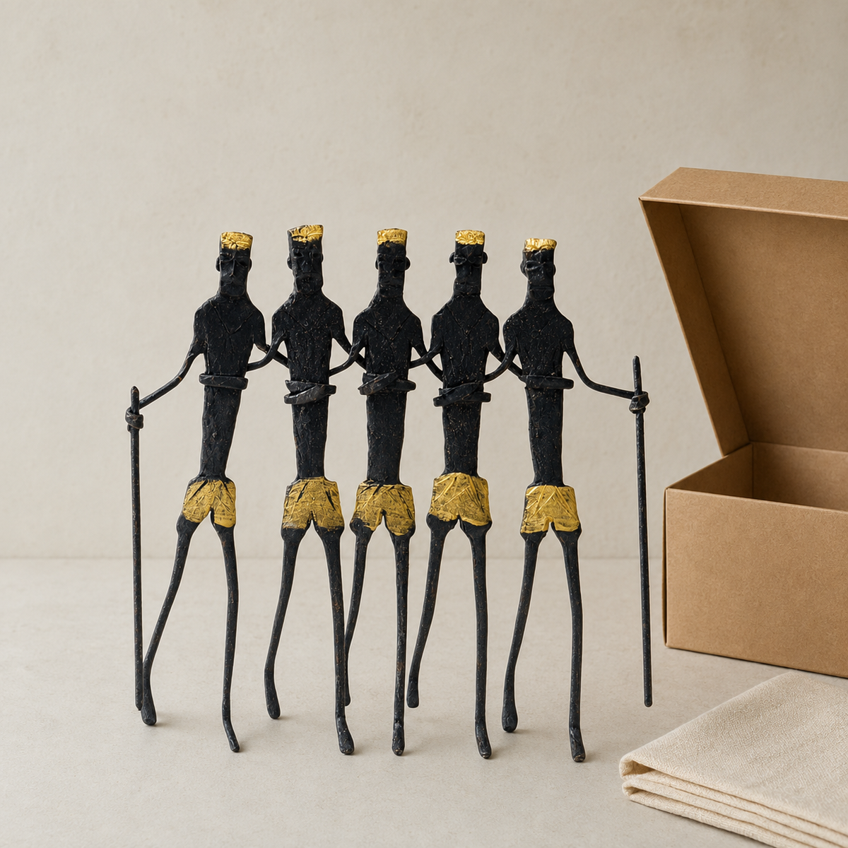 Five-piece Bastar tribal figure sculpture presented beside a kraft gift box