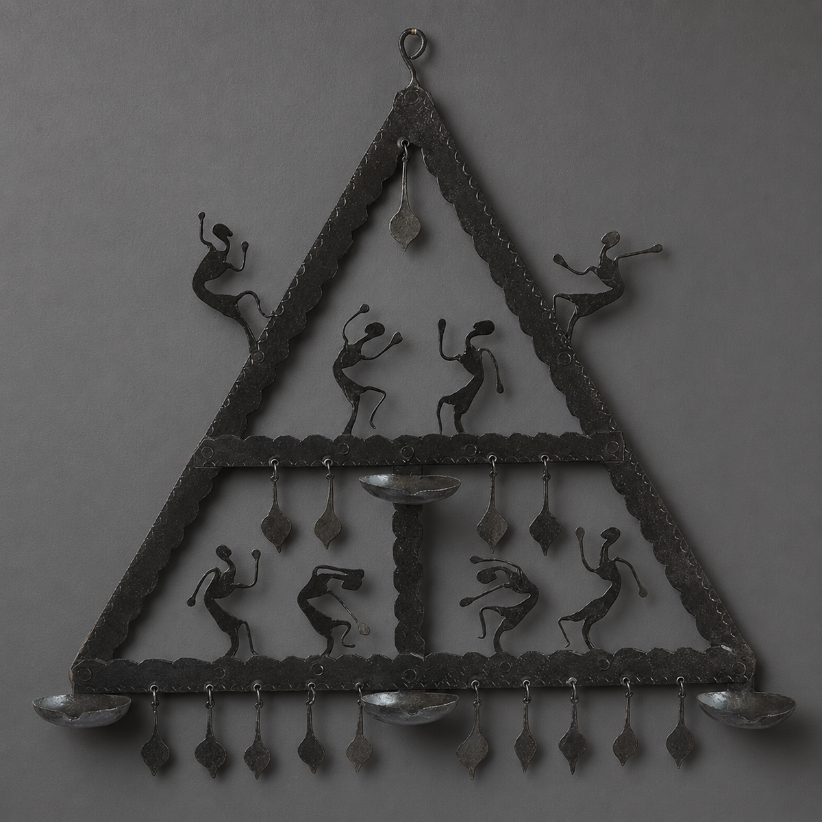 Detailed view of eight dancers, four trays and pendants on a Bastar iron wall hanging